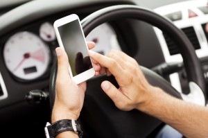 Young man using smart phone in her car