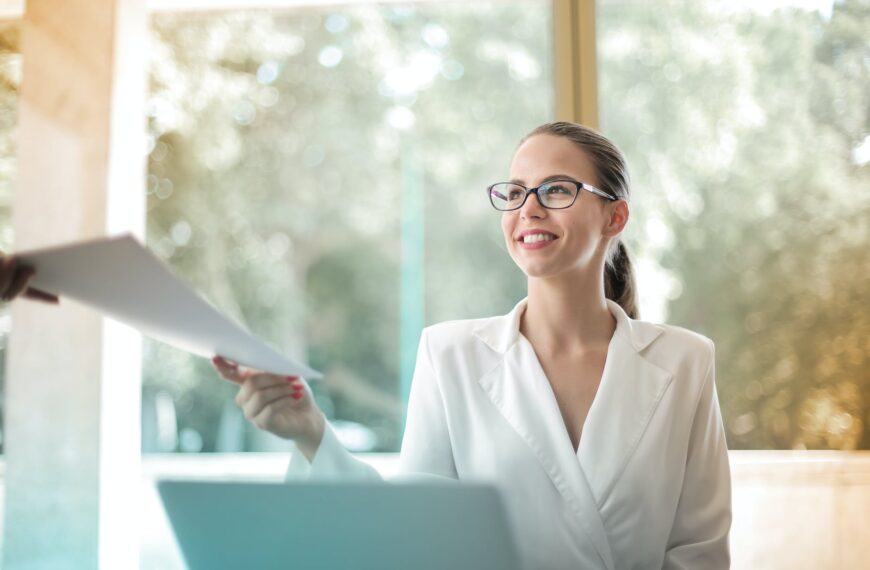 positive businesswoman doing paperwork in office